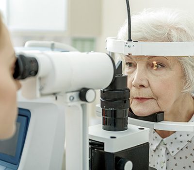 Eine Optikerin führt eine professionelle Augenanalyse bei einer Seniorin durch
